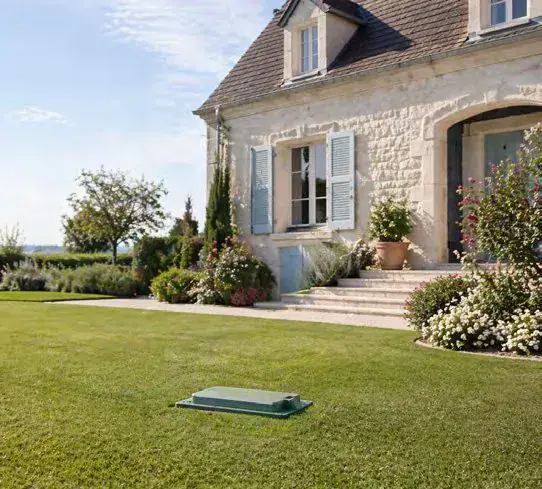 Maison en pierre et son jardin, regard de l'installation au premier plan